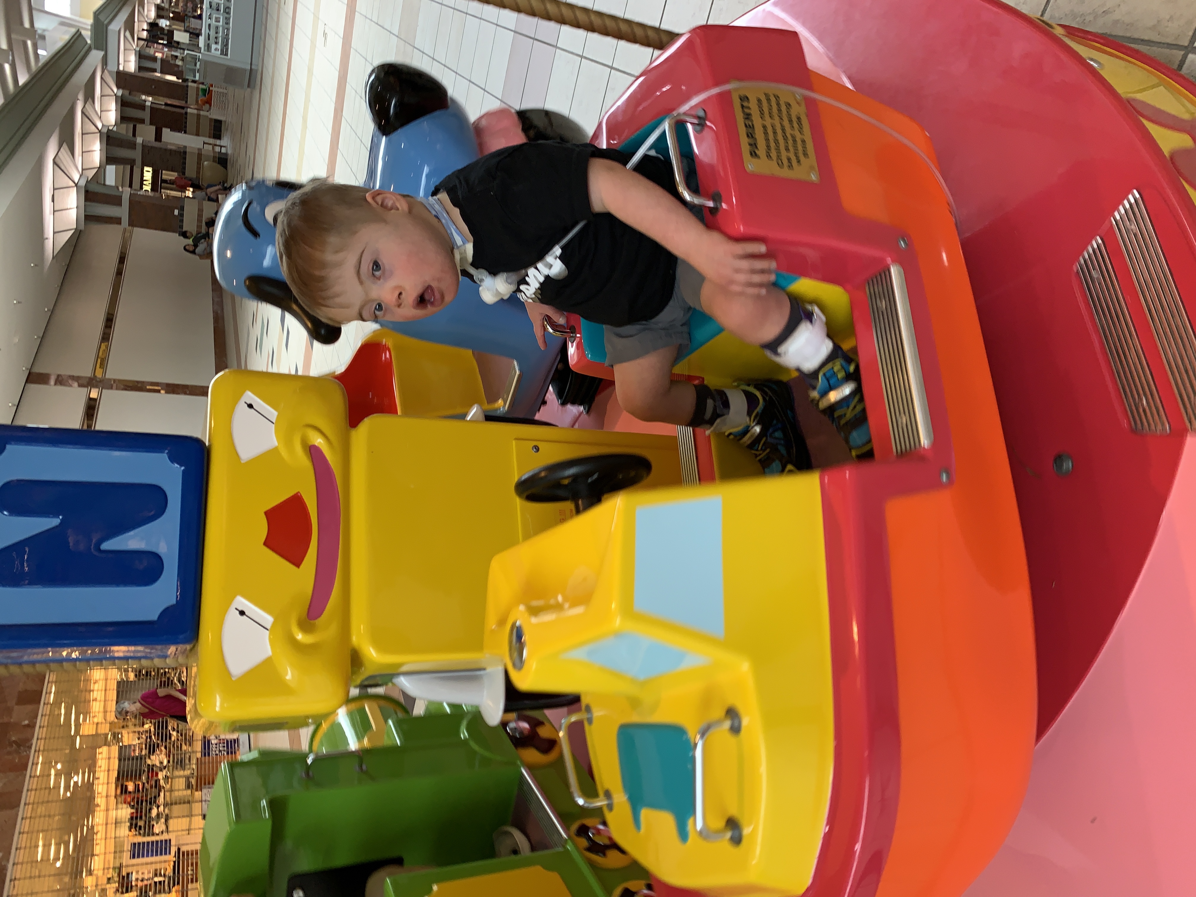 Boy with Down syndrome on small carousel 